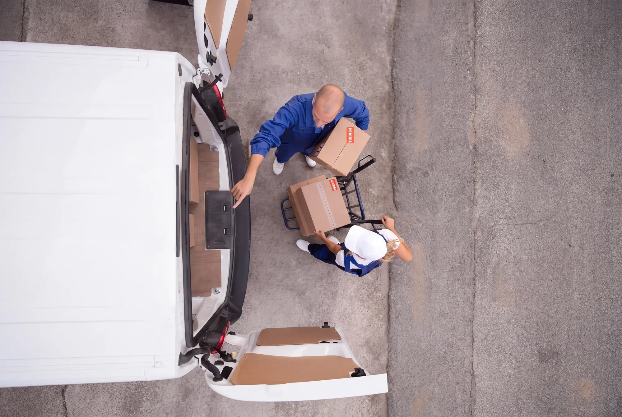 Seen from above: two BonCargo crew members load boxes from a hand truck into a van